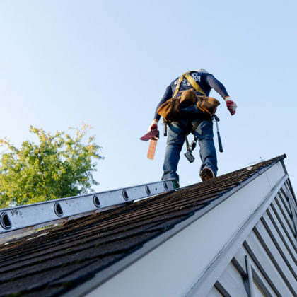 A roofer installing an asphalt shingle roof
