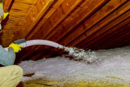 Technician spraying blown-in insulation into a home's attic