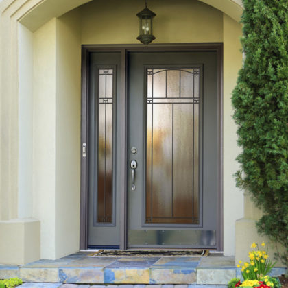 A front entry door with decorative glass and a sidelite