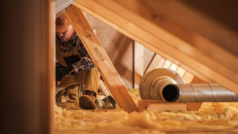 Contractor installing insulation in a home.