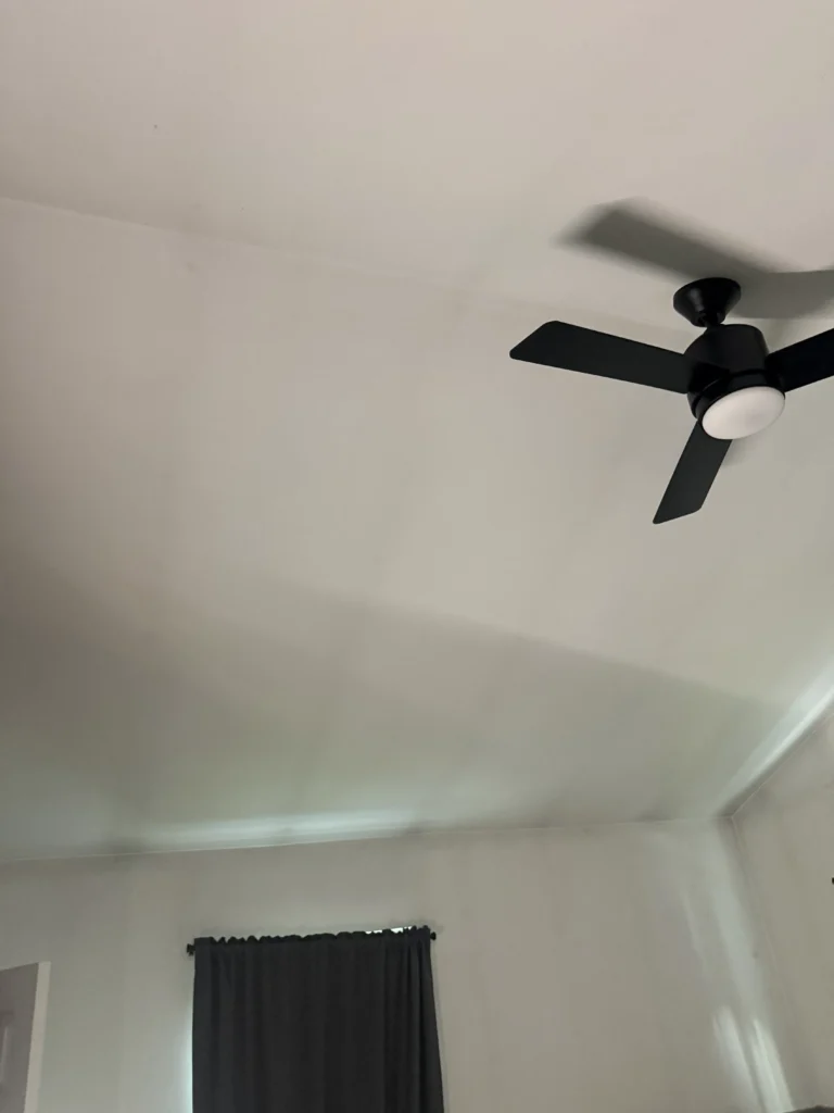 White ceiling in a bedroom with a ceiling fan, showing a smooth uniform surface without visible ghosting stains